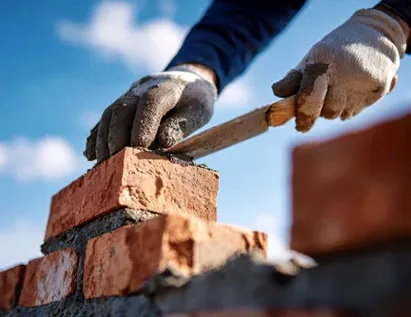 Mason laying brick in lime mortar on an Uptown Westerville chimney